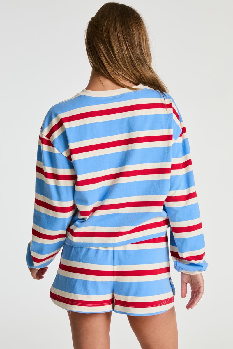 A woman shown from the back wearing a matching long-sleeve striped top and shorts set in light blue, red, and off-white, against a plain light gray studio background.